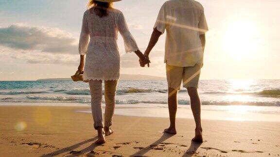 在奢华的海滩上漫步热带度假的快乐退休夫妇