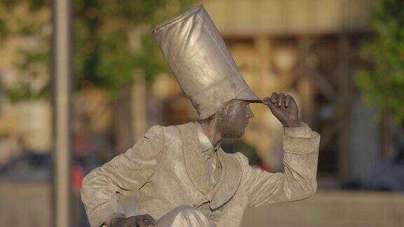 街头艺人打扮成银色雕像