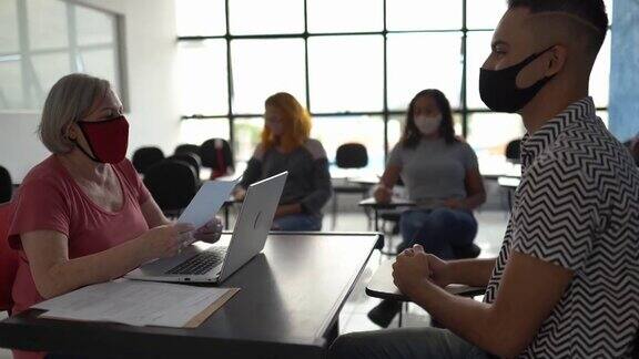 老师与学生谈论大学考试成绩或正在做的事情求职面试-戴口罩
