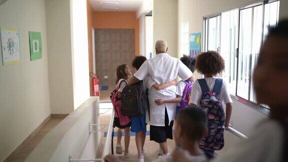 小学生走在学校走廊上拥抱老师