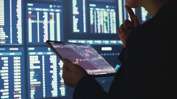 商人在数字平板电脑上分析股票市场数据图