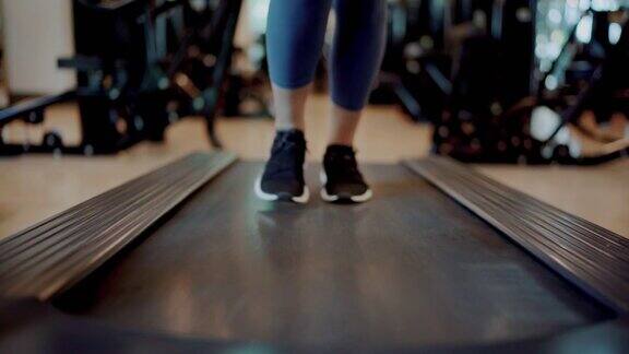 在健身房跑步机上跑步的女人的腿