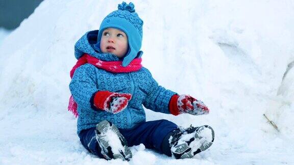 孩子坐在雪地里