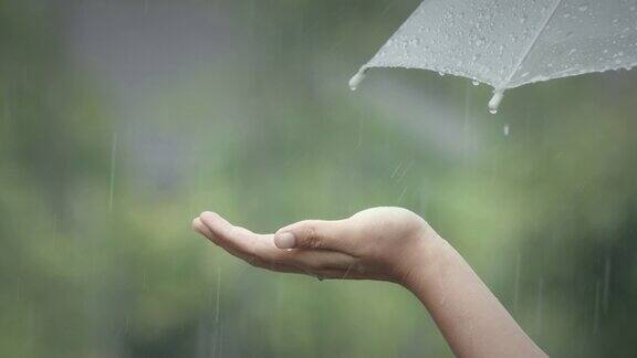 女人在雨中用手掌抓住雨滴