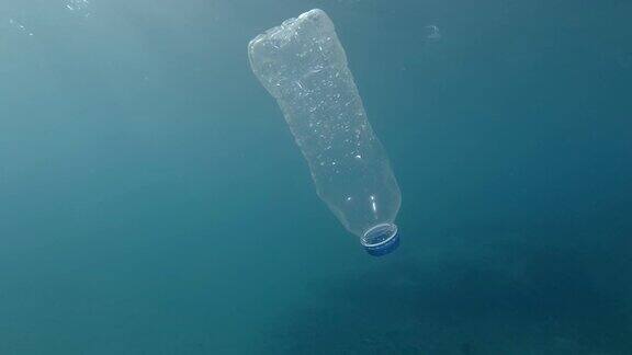塑料污染塑料瓶在bubuwater废弃的塑料瓶在阳光下慢慢漂浮在蓝色的水面下漂浮在欧洲地中海的塑料瓶