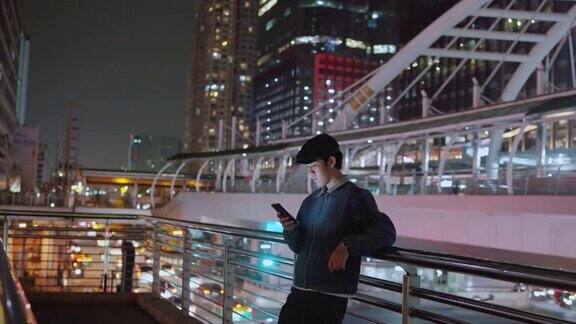 男性晚上在城市里使用智能手机
