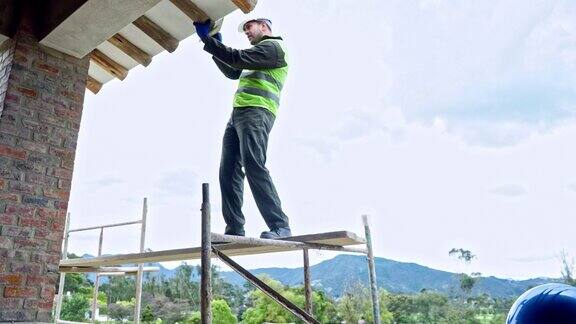 建筑工人正在采取一切保护措施修理屋顶