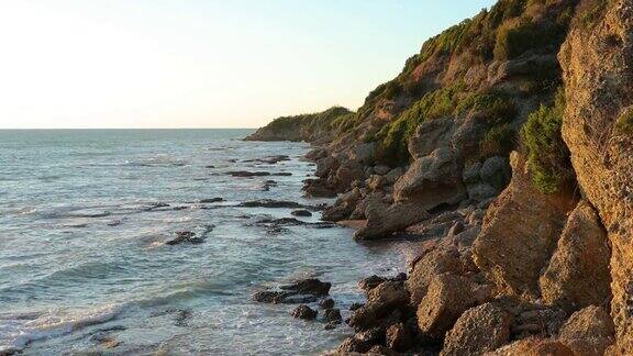 在阿尔巴尼亚的岩石海岸线海广场Gjeneralit海滩日落