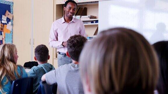 男老师在小学课堂上与学生交谈