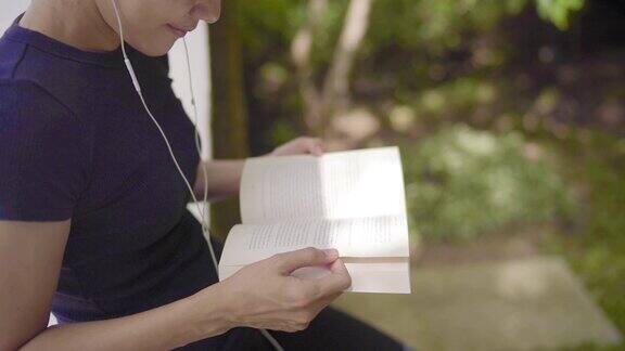 女人放松和阅读与入耳耳机