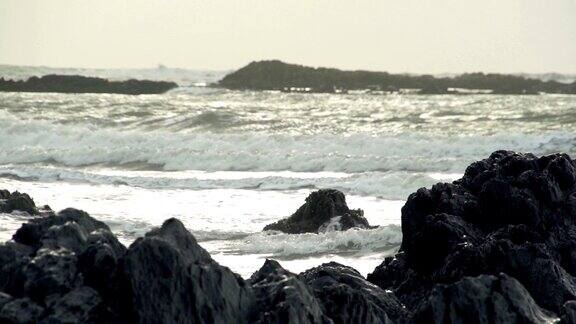 阳光在暴风雨的岩石海滩上