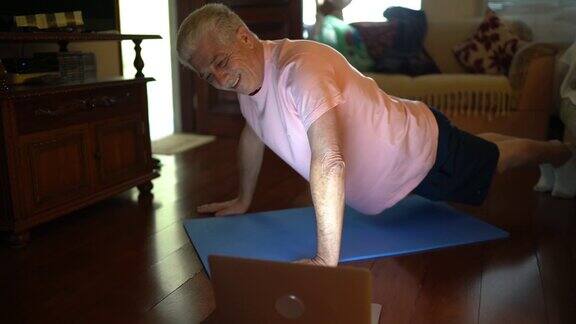 老人在电脑上看体育课在家做运动