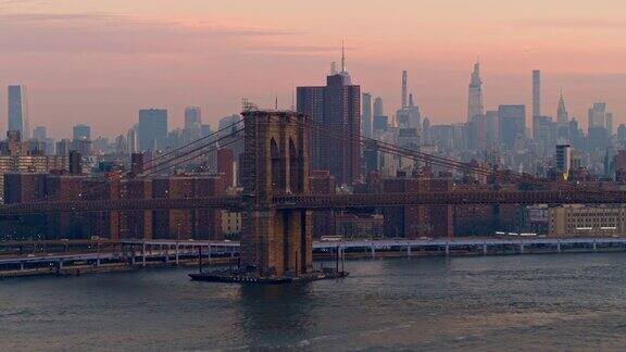 空中俯瞰布鲁克林大桥以曼哈顿为背景在东河对岸清晨的晨曦中被雾气笼罩着无人机视频与向前摄像机运动