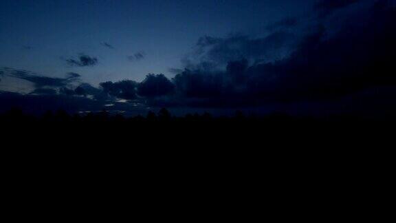 在昏暗的晨光中黎明前的云在森林地平线上生长的时间流逝