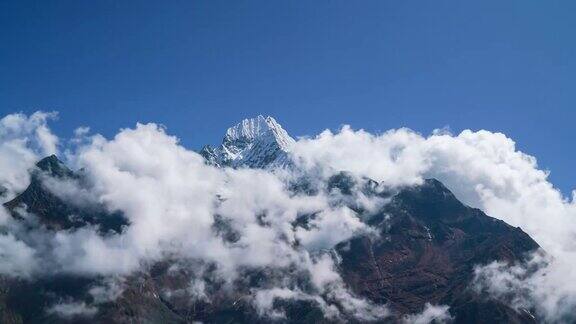 4K时间的连续镜头白色蓬松的云绕着高喜马拉雅山峰旋转