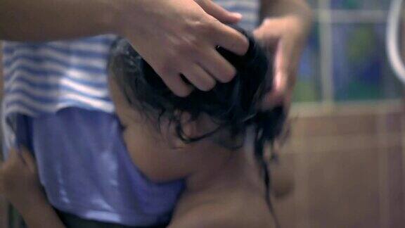 亚洲小女孩洗澡和洗头发由她的母亲