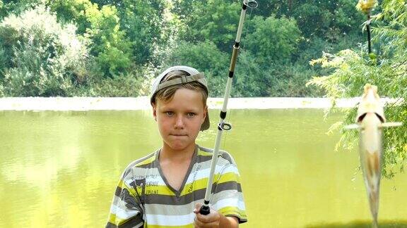年轻的白人男孩与钓鱼杆和鱼