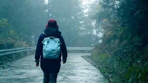 背着背包的女人走在森林的路上