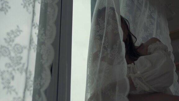 4K沮丧美丽的亚洲女人独自站在公寓房间的窗口哭泣和尖叫孤独悲伤的女孩想起悲伤烦恼消极情绪与心理健康