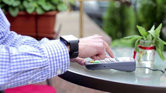 商家通过餐厅的终端使用智能手表进行非接触式支付