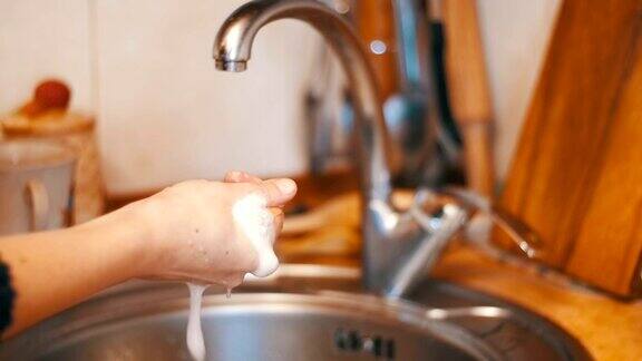 在家庭厨房里用海绵和洗涤剂洗盘子的女人慢动作