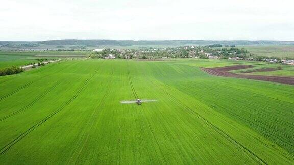 拖拉机正在麦田里喷洒农药农机向绿油油的田野喷洒杀虫剂农业自然春耕