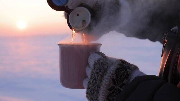 在下雪天把热水瓶里的茶倒进杯子里