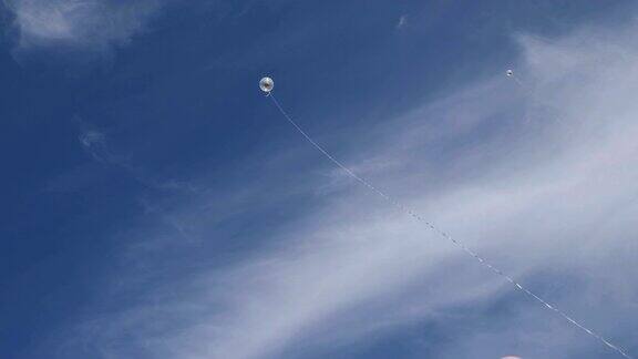 蓝天中系着长线的气球
