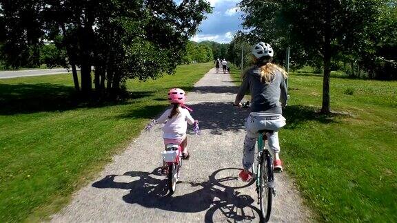 妈妈和女儿在公园里骑自行车