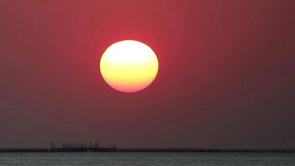 日出在红色的晴朗的天空在浅橙色的云在海上时间流逝