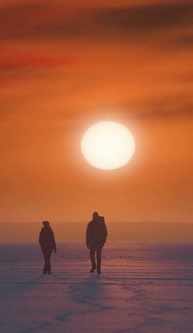 两名游客在日落背景下走过雪原慢动作