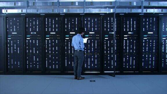 IT专家站在服务器机架前用一个触摸手势激活数据中心打开新的数据中心