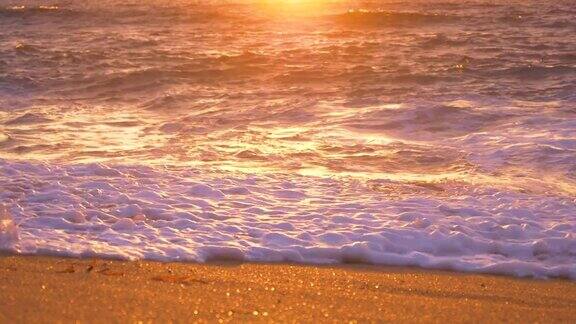 慢镜头:金色的阳光照在平静的海面上冲刷着沙滩