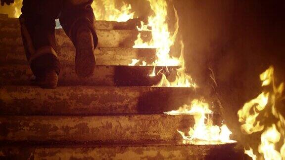 特写消防队员的腿跑上燃烧的楼梯大楼着火了到处可见明火缓慢的运动