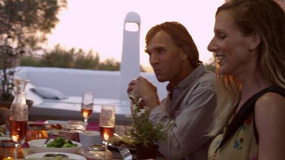 手持近距离的两对夫妇在露台上吃晚餐在R3D上拍摄