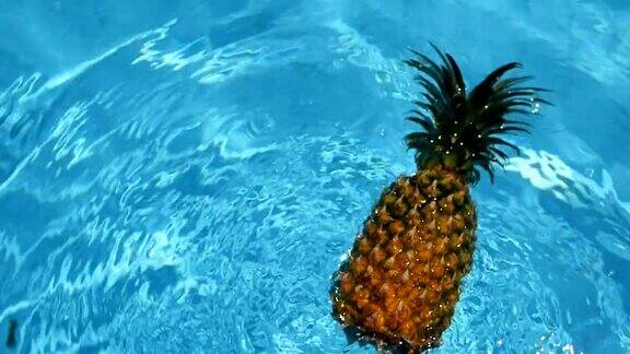 菠萝漂浮在游泳池的蓝色的水健康生有机食品多汁的水果素食纯素营养维生素饮食暑假假期概念奇异的热带背景