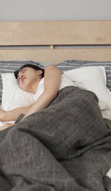 垂直屏幕:不安的亚洲年轻的韩国妇女患有失眠在家里卧室不舒服的床垫上辗转反侧