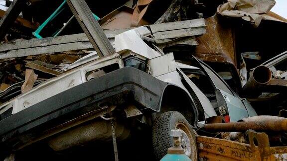 报废的汽车躺在废金属堆里