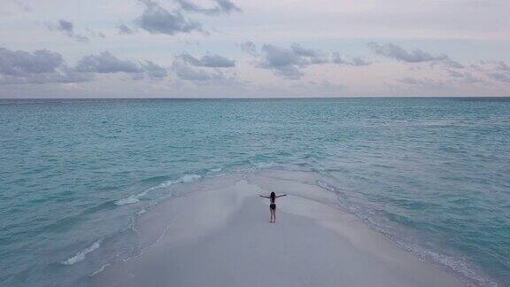 年轻的成年女子走在马尔代夫碧绿的沙滩上