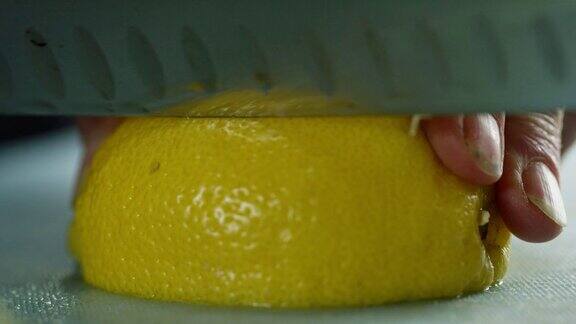 一位年长的白人妇女用菜刀在切菜板上切柠檬