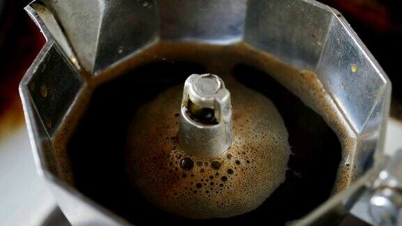 烤炉上的摩卡壶意大利浓缩咖啡在摩卡壶沸腾特写