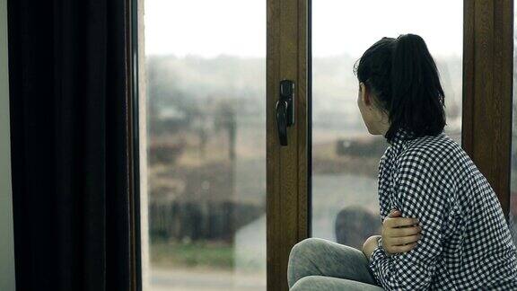 年轻女子坐在窗边