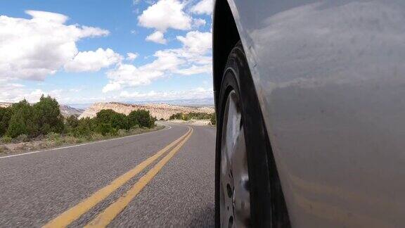 从侧面的一个银色的车辆而驾驶下的科罗拉多国家纪念碑附近大汇点科罗拉多在一个部分多云的天空下