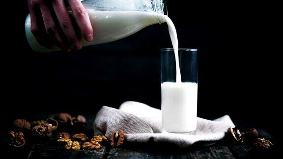 牛奶倒进一个放着胡桃和核桃的杯子里