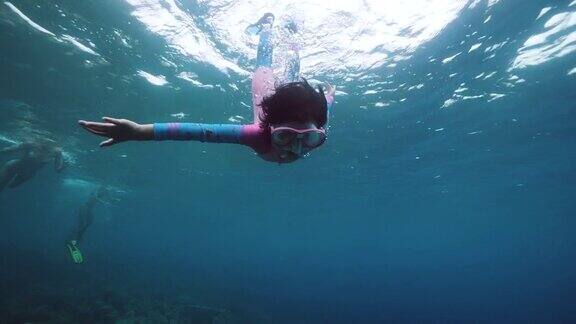 一个勇敢的小女孩独自在蓝色的深海里游泳和潜水