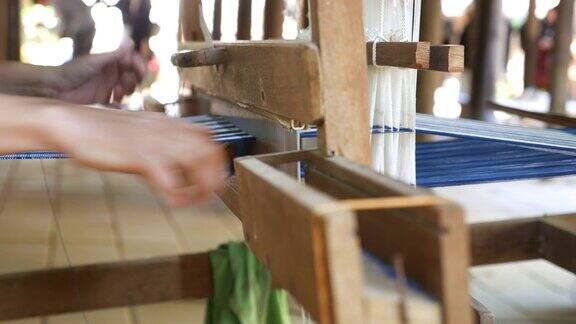 妇女在手工织布机上以传统方式织造丝绸