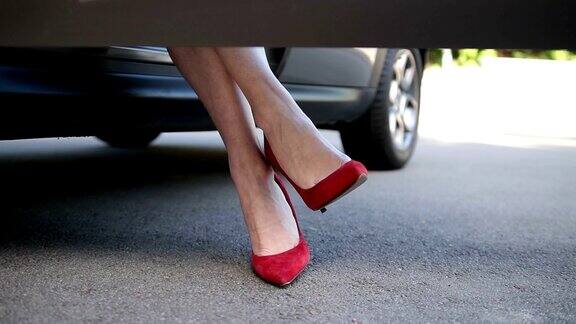 穿着红色高跟鞋坐在车里的女人