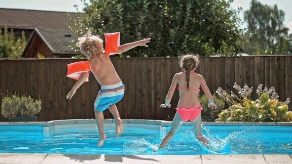 小女孩和她的弟弟跳进游泳池