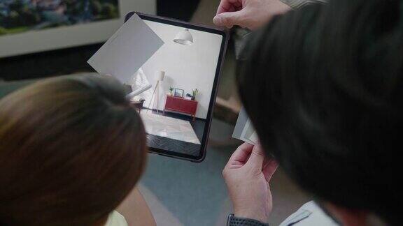 一对年轻的日本夫妇用平板电脑帮助他们规划家庭装修