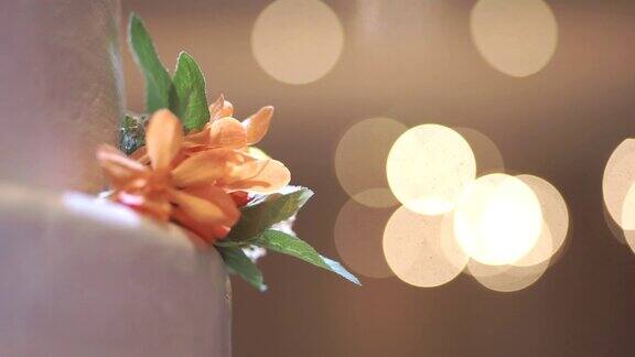 CU多利右相机白色婚礼蛋糕装饰花与散景光背景室内